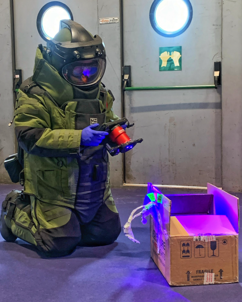 Crime-lite AUTO user in full hazmat CBRN suit examines forensic evidence